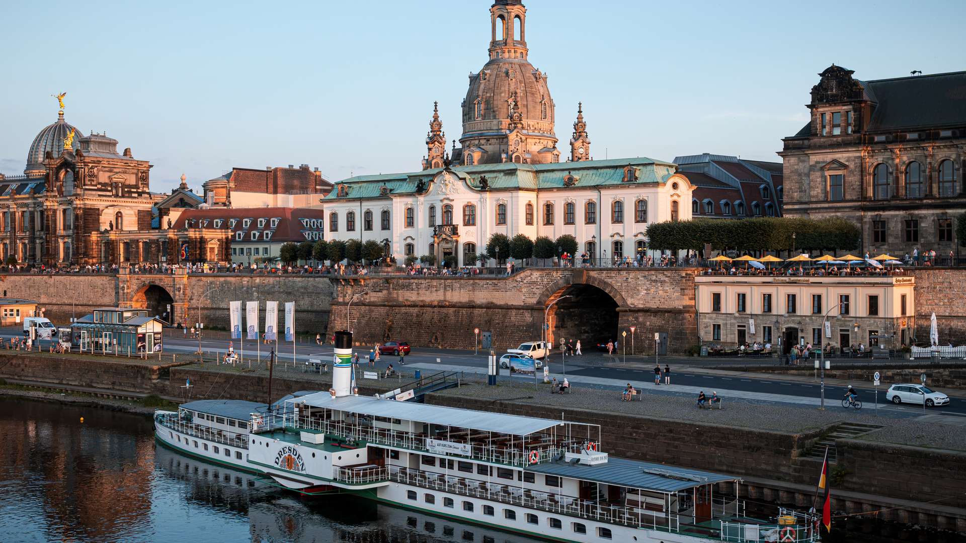 The Frauenkirche dome and the Brühl Terrace above the Elbe at sunset, with a paddle steamer moored below, Dresden