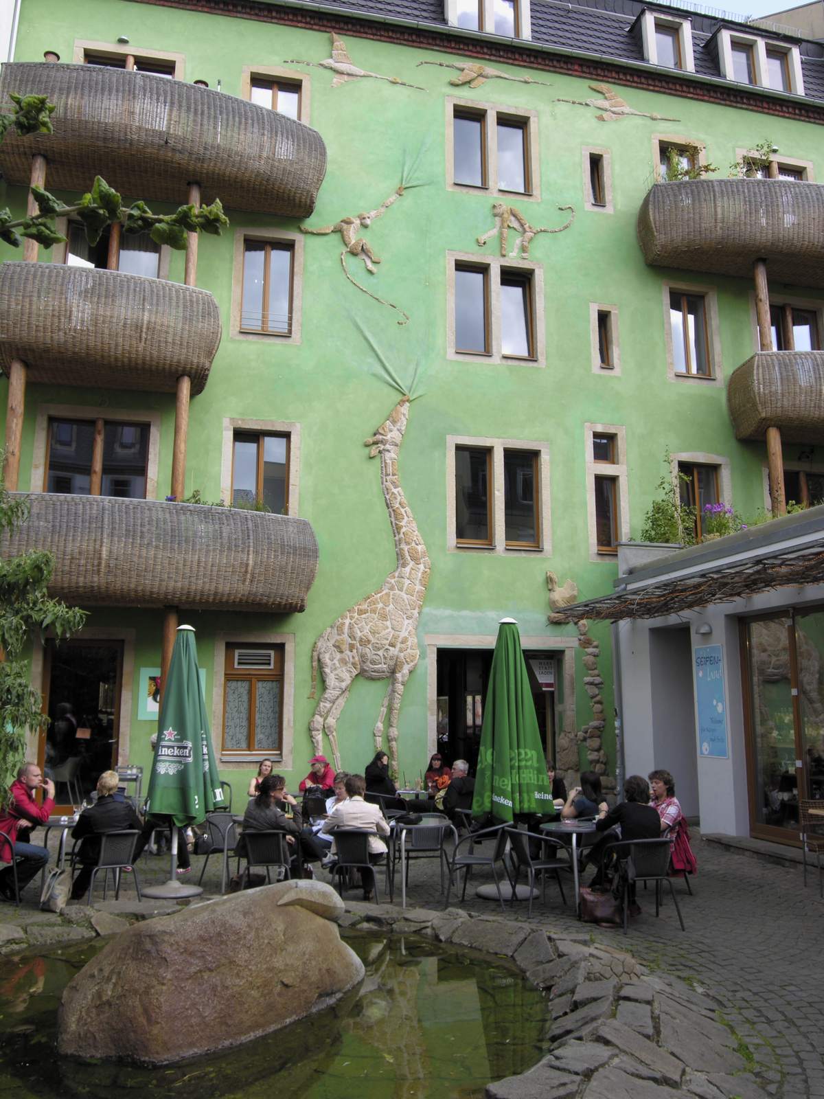 The green Courtyard of Animals in the Kunsthofpassage, Dresden Neustadt, with a painted giraffe on the facade