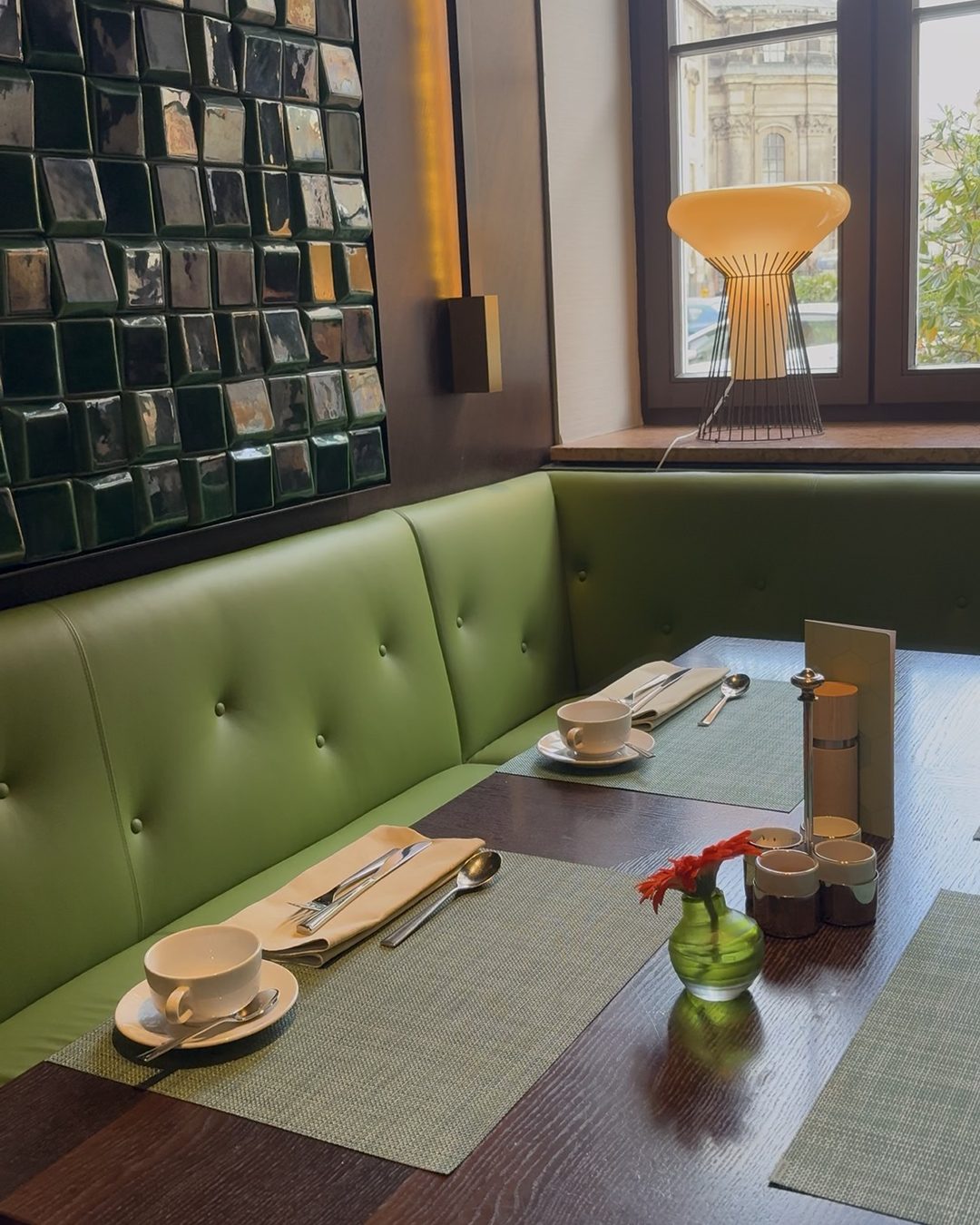 A breakfast table at the Gewandhaus Dresden, with green banquette seating by the window