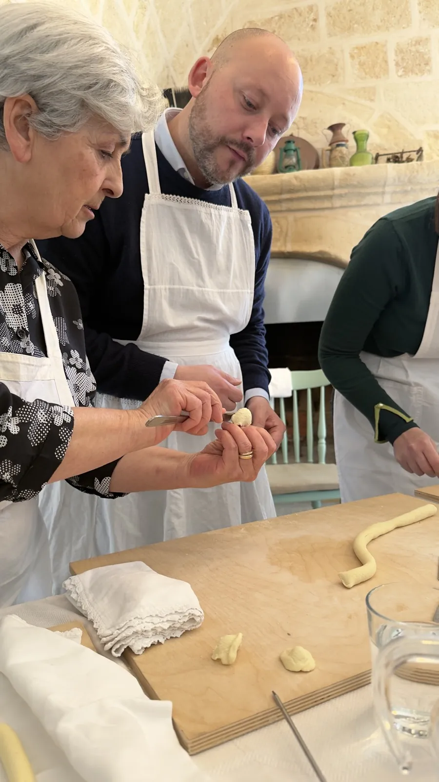 Making orecchiette by hand at a family cooking table in Puglia