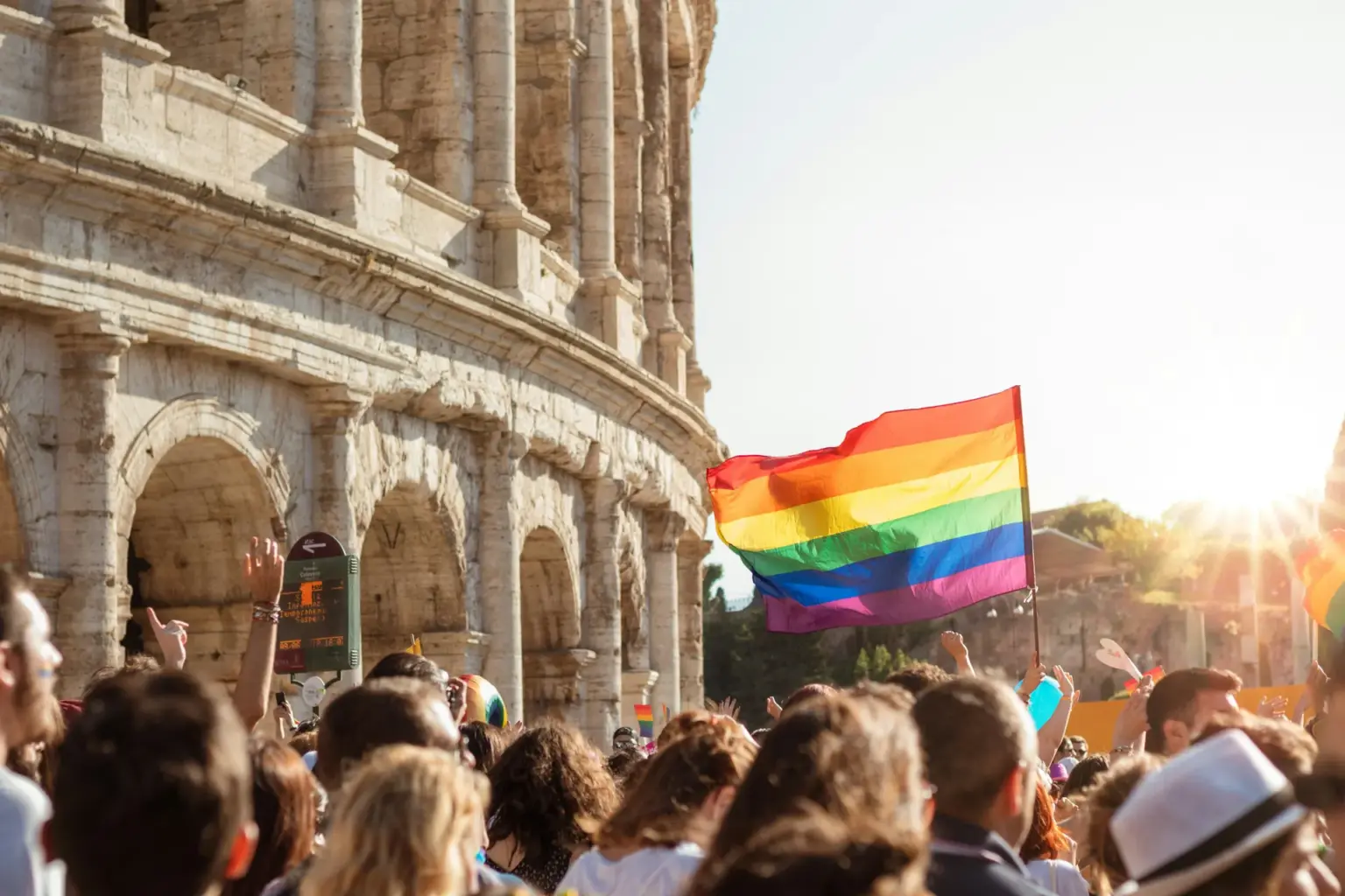 Rainbow flag over the Rome Pride crowd in front of the Colosseum, Italy